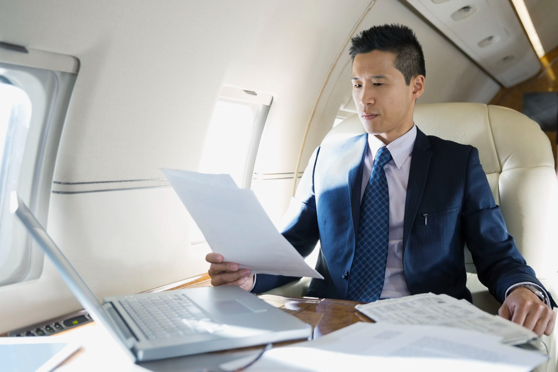 businessman works on his laptop during areoplane flight